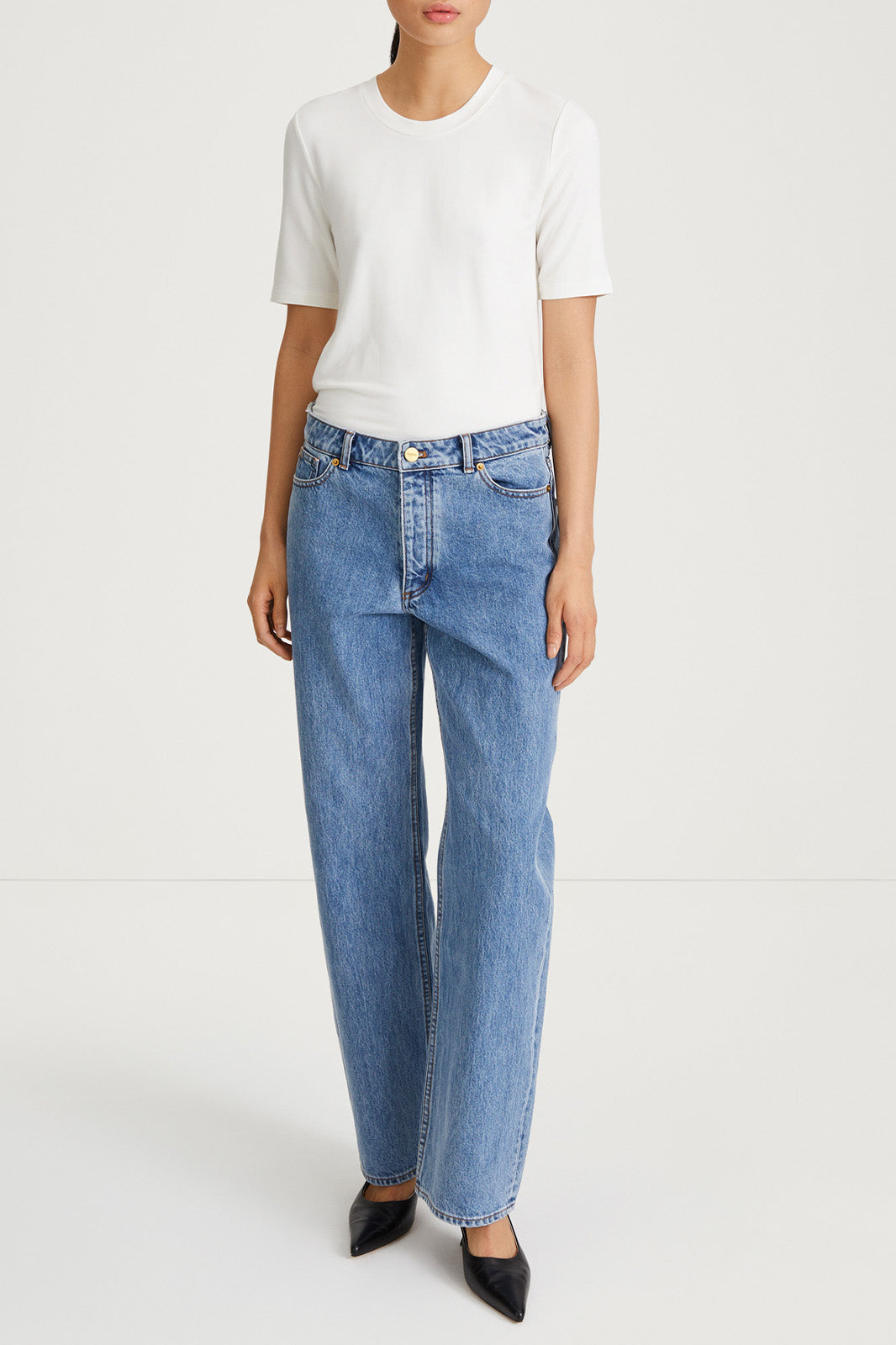 A pair of vintage blue denim jeans with a high waist and straight leg fit, paired with a white t-shirt.