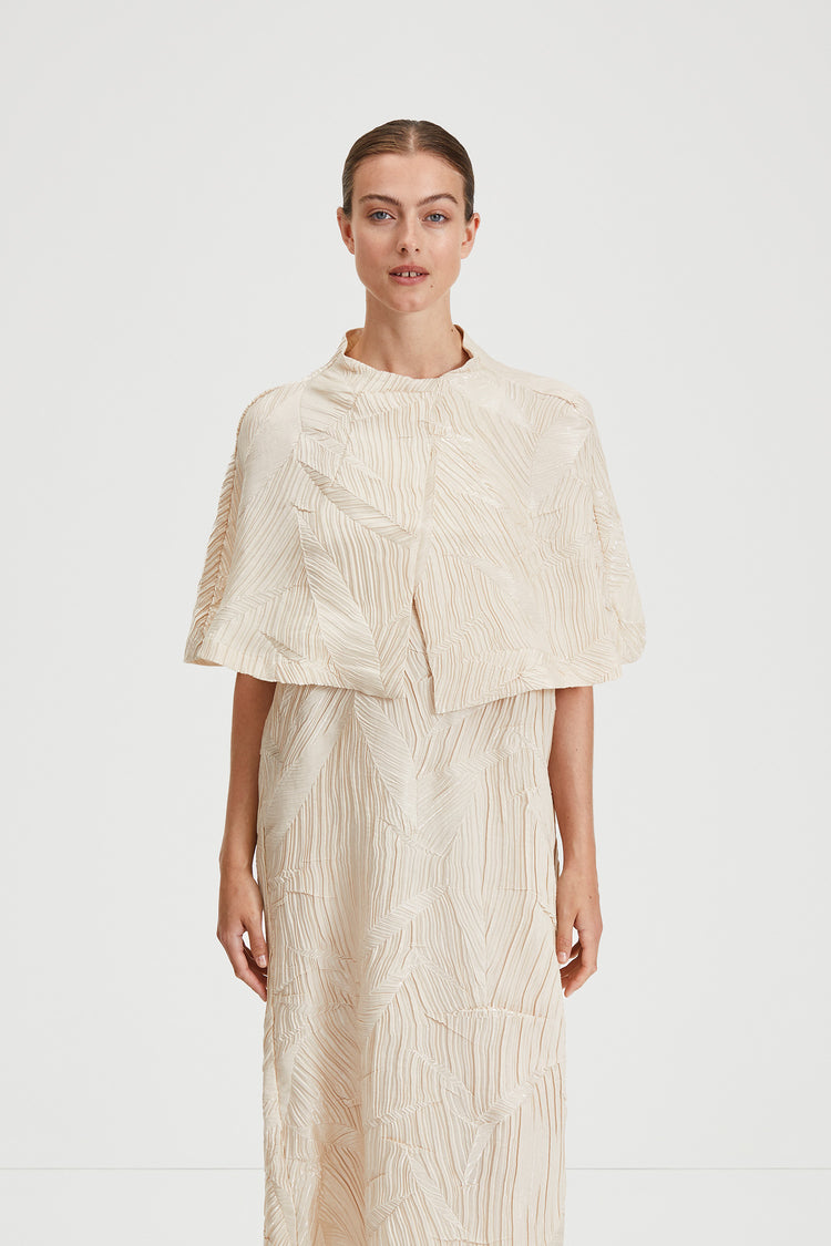 Ida cape crushed plisse fabric built up neckline darts front and back sand stylein front image
